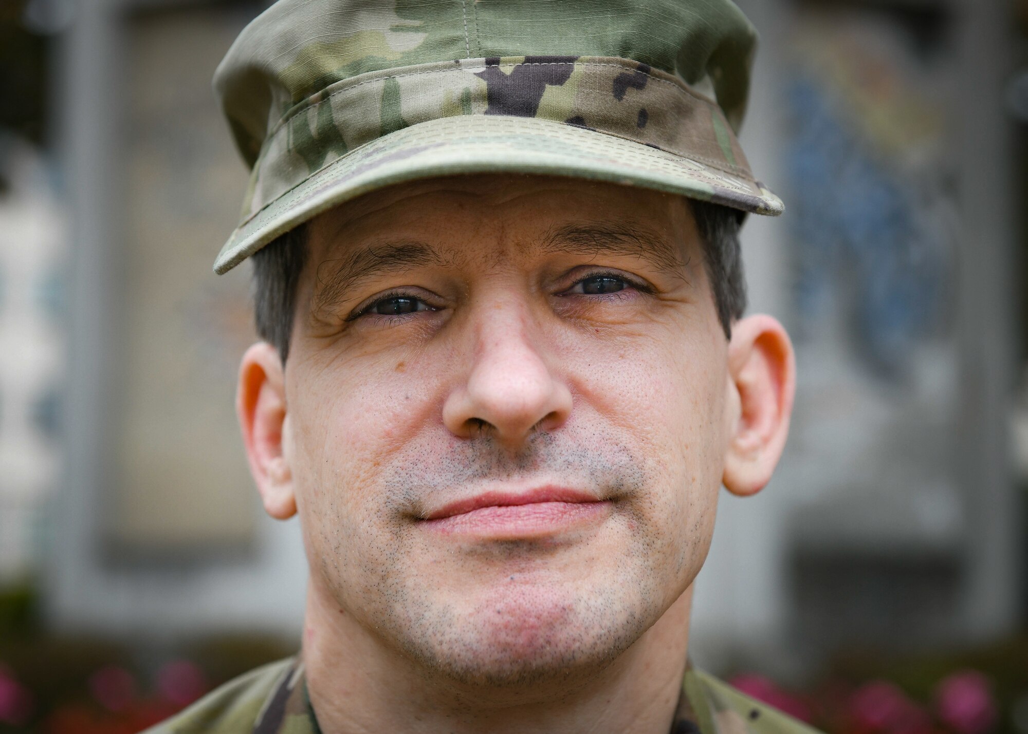 Tech. Sgt. Michael Brown, 435th Air Expeditionary Wing client systems craftsman, poses for a photo in front of a piece of the Berlin Wall at Ramstein Air Base, Germany, Oct. 1, 2020. Brown has been in the military for about 30 years and has served in three different branches.  (U.S. Air Force photo by Senior Airman Madeline Herzog)