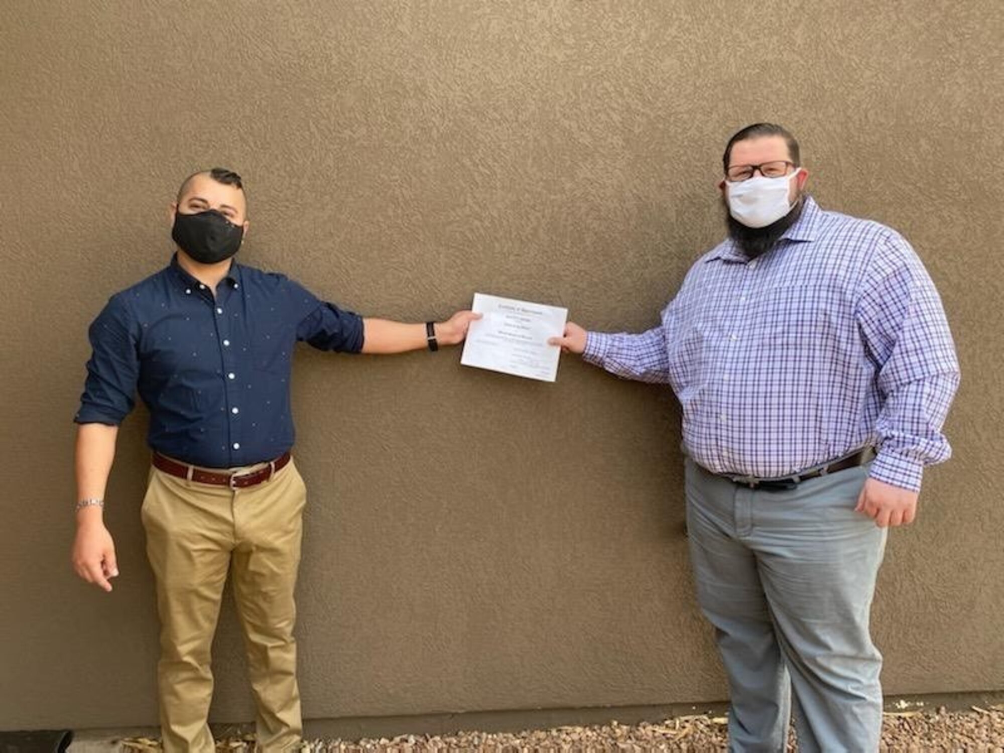 Brett Moore, left, receives his Contracting Officer Warrant from Kyle Hunter. (Courtesy photo)