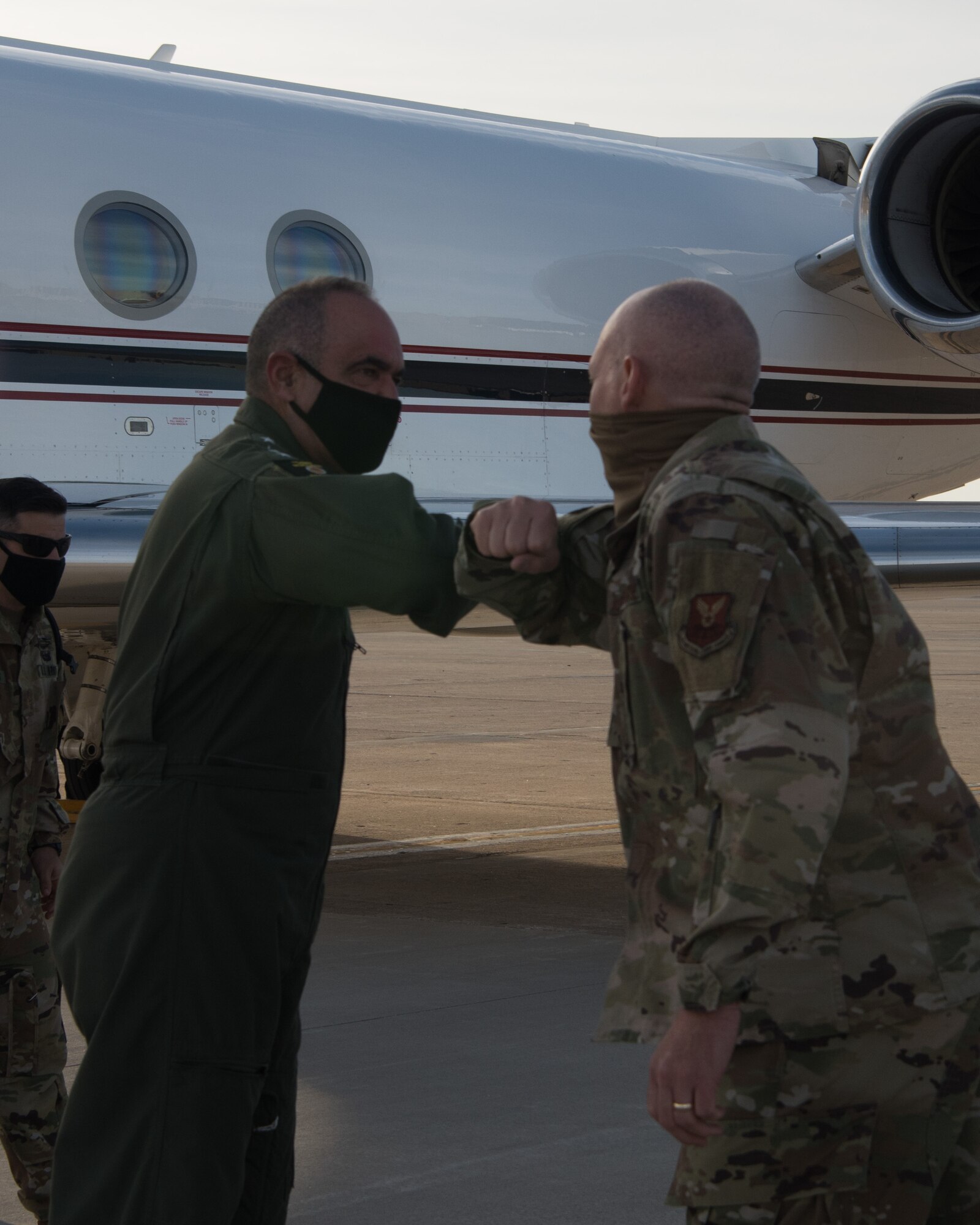 Admiral Charles Richard, the U.S. Strategic Command commander, bumps elbows to greet Colonel Christopher Callis, 509th Mission Support Group commander.