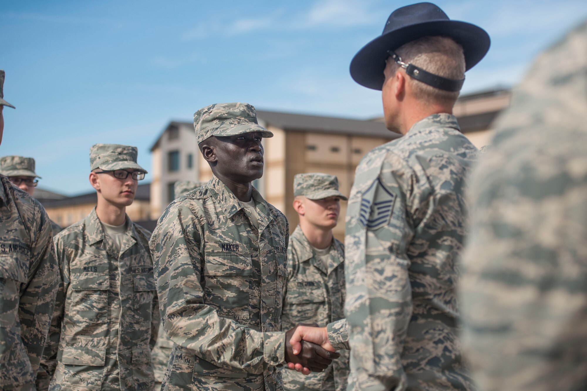Gour Maker, a trainee at Air Force Basic Military Training, receives an “Airman’s Coin” at the Coin Ceremony Feb. 1, 2018 outside the Pfingston Reception Center at Joint Base San Antonio-Lackland, Texas. During the BMT Coin Ceremony Trainees are given “Airman’s Coins’ signifying the final transition from trainee to Airman. (U.S. Air Force photo by Airman 1st Class Dillon Parker)