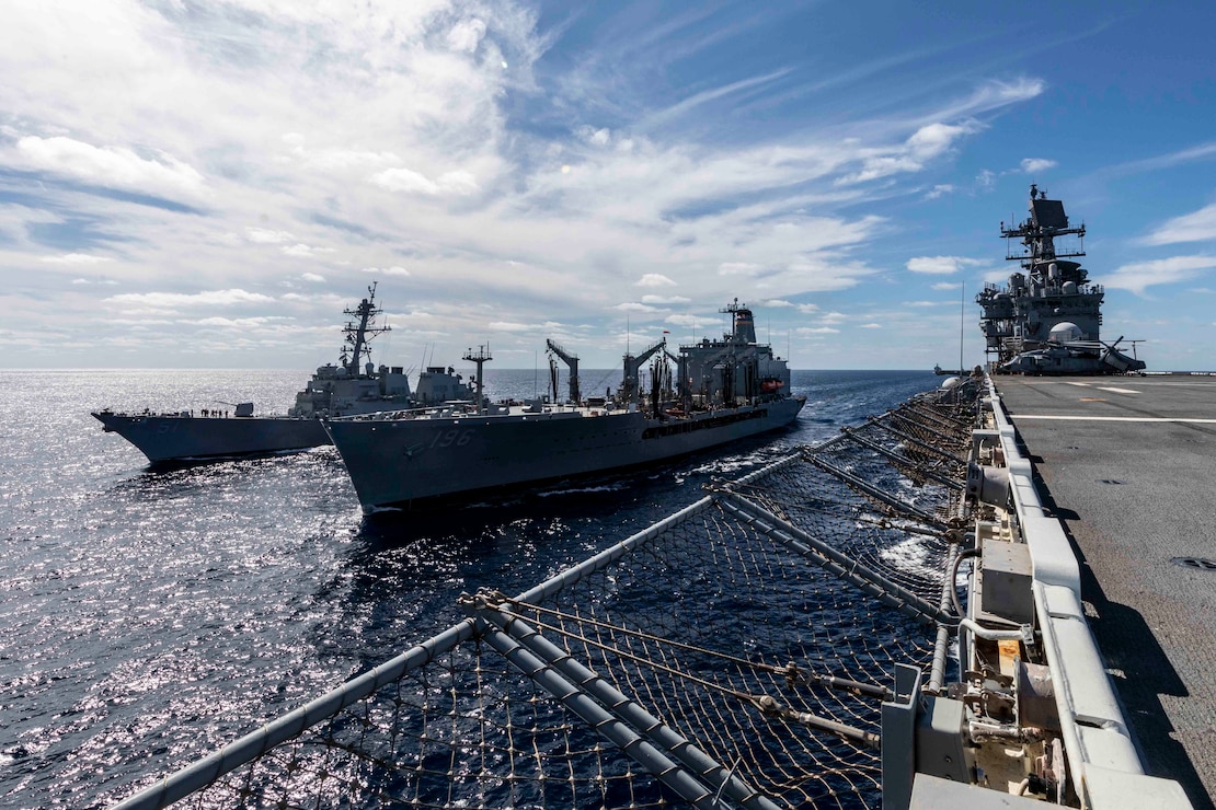 The Arleigh Burke-class guided-missile destroyer USS Arleigh Burke (DDG 51), left, and the Wasp-class amphibious assault ship USS Iwo Jima (LHD 7) come alongside the Henry J. Kaiser-class fleet replenishment oiler USNS Kanawha (T-AO 196) during a replenishment-at-sea during their Surface Warfare Advanced Tactical Training (SWATT), Oct. 15, 2020.