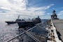 The Arleigh Burke-class guided-missile destroyer USS Arleigh Burke (DDG 51), left, and the Wasp-class amphibious assault ship USS Iwo Jima (LHD 7) come alongside the Henry J. Kaiser-class fleet replenishment oiler USNS Kanawha (T-AO 196) during a replenishment-at-sea during their Surface Warfare Advanced Tactical Training (SWATT), Oct. 15, 2020.