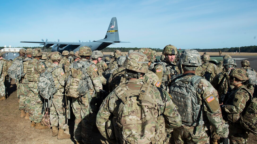 Military members line up for transportation to an exercise location.