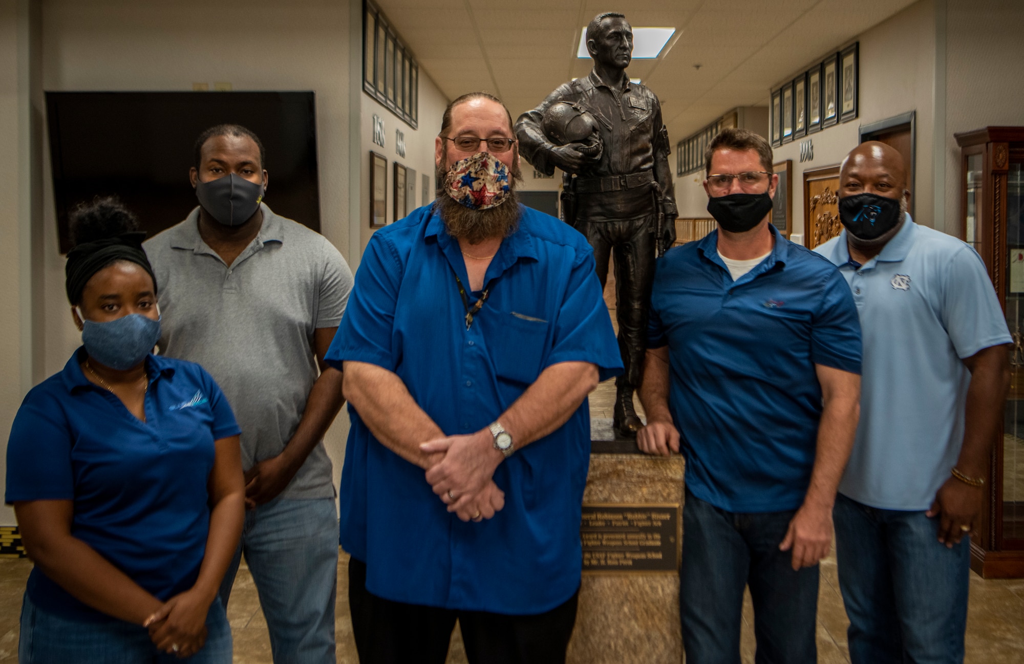 Group stands in front of a statue.