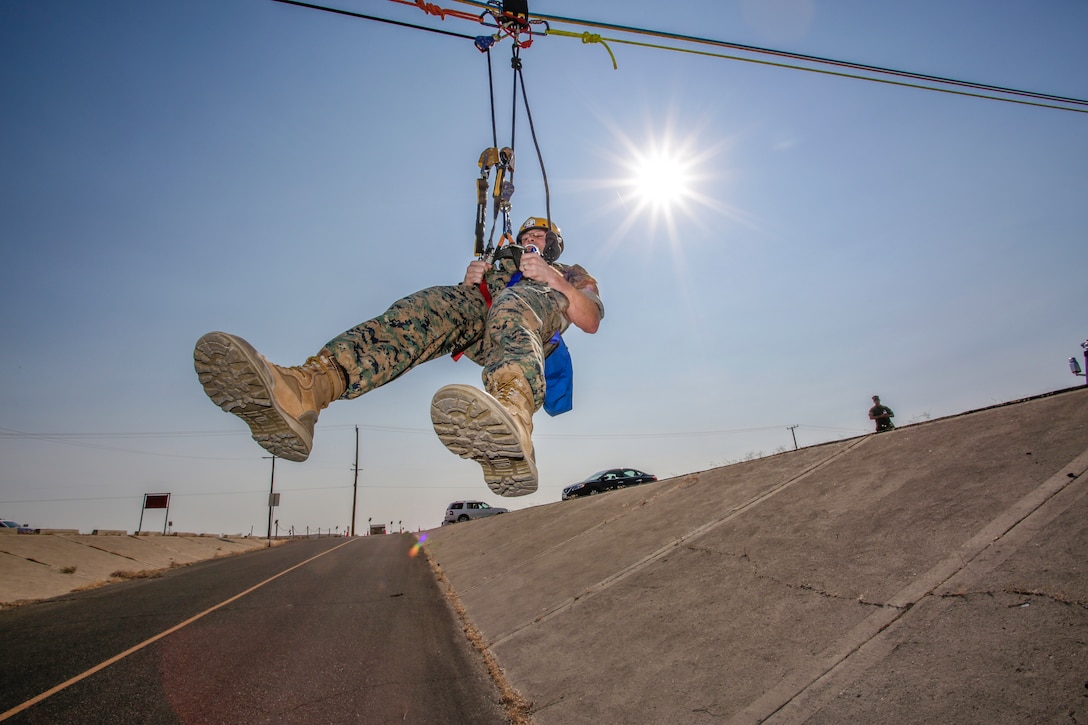 Colonel Craig Clemans, base commanding officer, is hoisted over a street to simulate a swift water rescue by Fire and Emergency Services personnel during training aboard Marine Corps Logistics Base Barstow, California, Sept. 23.