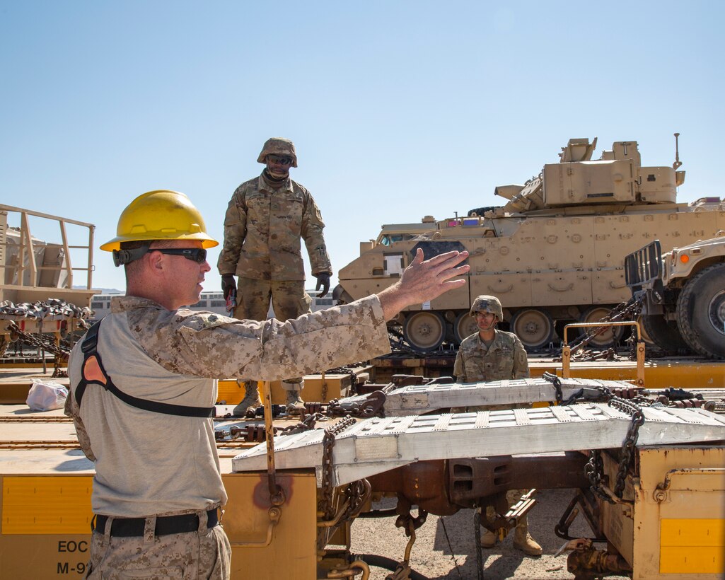 Staff Sergeant Michael Bigelow, staff noncommissioned officer in charge, offers instructions to soldiers as they load and tie down equipment onto railcars as part of their period of instruction in the Railhead Operations Group training course on the Yermo Annex aboard Marine Corps Logistics Base Barstow, California, Oct. 1. Bigelow is one of 35 Marines attending the course as part of their preparation for an upcoming McCree testing phase.