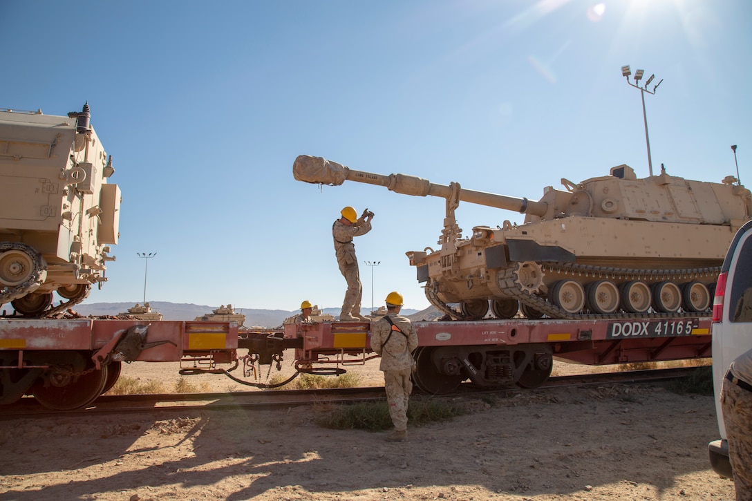 Marines work together to load a tracked vehicle onto a railcar as part of their training in Railhead Operations Group on the Yermo Annex aboard Marine Corps Logistics Base Barstow, California, Oct. 1.