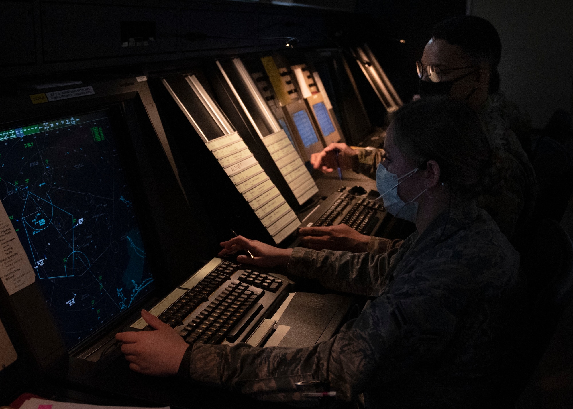 Airman 1st Class McKenzie Paul, 4th Operation Support Squadron air traffic controller apprentice, ensures the safe and expeditious movement of air traffic in the position of approach controller and Senior Airman Rocky Sparks (back), 4th OSS air traffic controller journeyman, assists in coordinating with adjacent airspace facilities and arrivals in the position of approach assistant at Seymour Johnson Air Force Base, North Carolina, Sept. 10, 2020.