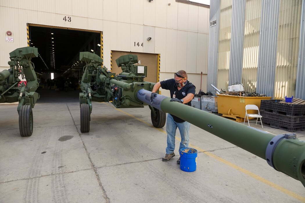 Michael Brown, supervisor, M-777 howitzer section, greases up the exposed portion of the 777 to protect it from the effects of the baking sun at Production Plant Barstow, Marine Depot Maintenance Command, aboard the Yermo Annex of Marine Corps Logistics Base Barstow, California, Oct. 6.