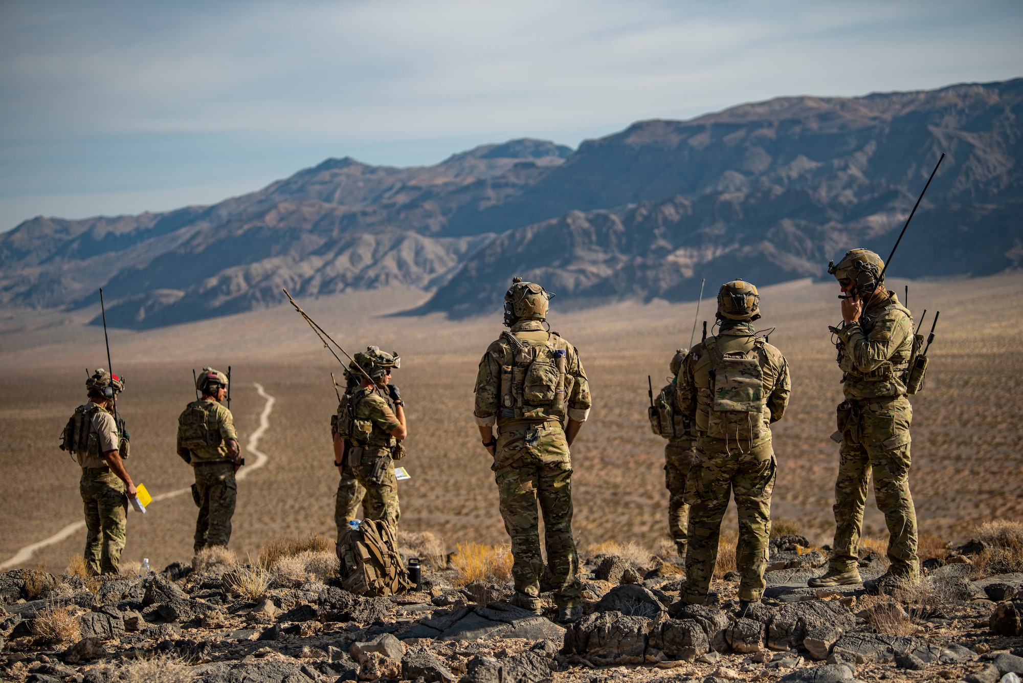 Airmen stand on hill.