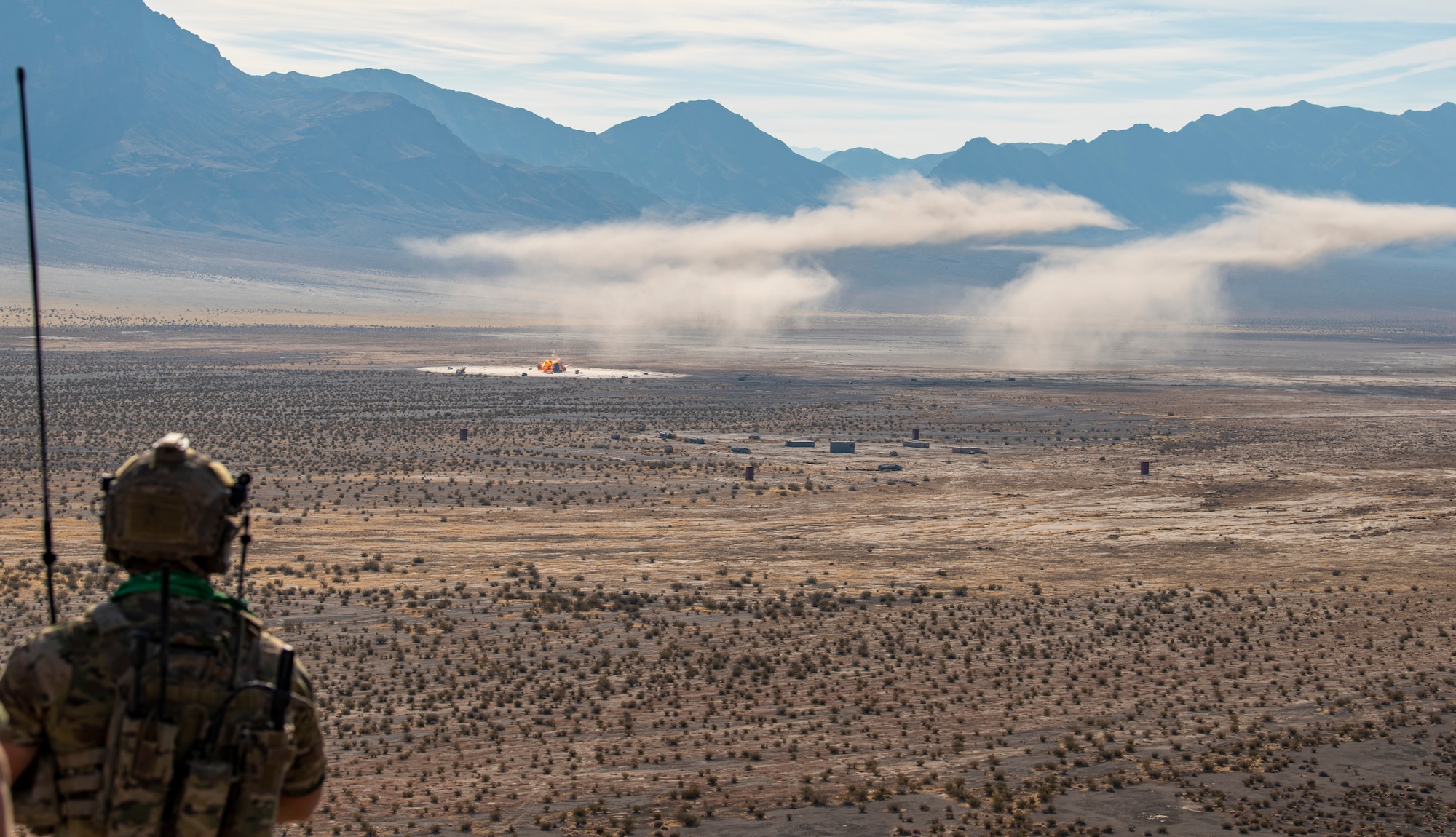 Airman stands on hill and looks out on range.