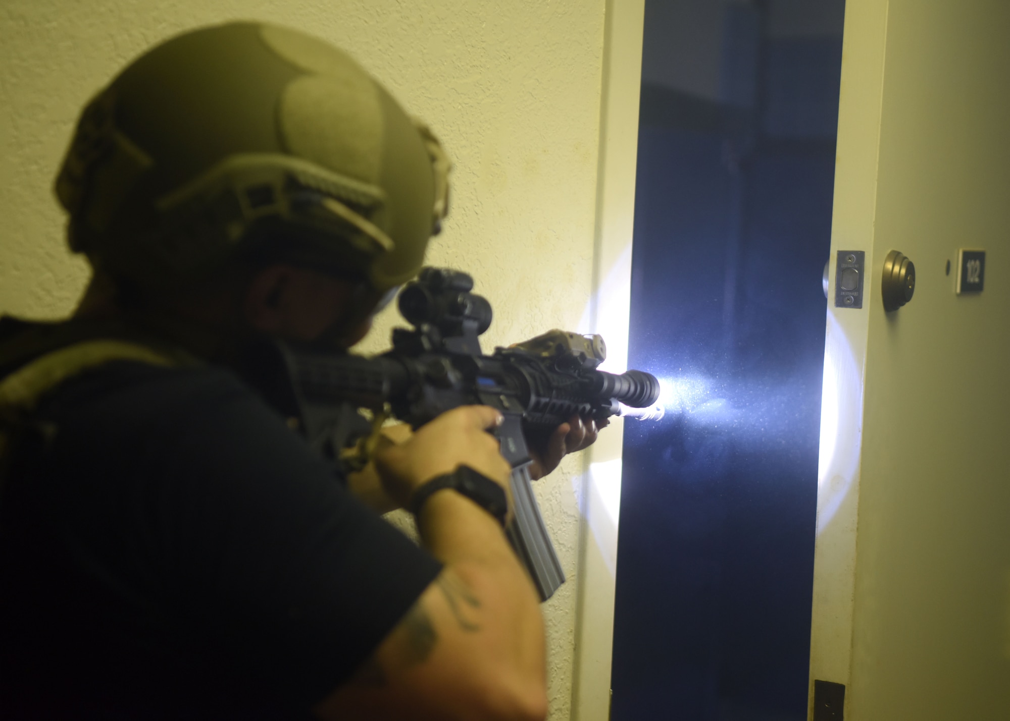 A 17th Security Forces defender peeks into a bathroom while waiting to enter during close-quarters battle training on Eldorado Air Force Station, Texas, Oct. 9, 2020. Each member played a specific role that required the team to work in tandem to secure the objective. (U.S. Air Force photo by Airman 1st Class Ethan Sherwood)