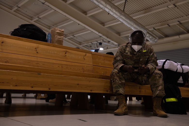 A U.S. Airman with the 606th Air Control Squadron uses his phone while waiting to leave for a deployment from Aviano Air Base, Italy, Oct. 10, 2020. The 606th ACS deployed to six locations in Southwest Asia. (U.S. Air Force photo by Senior Airman Caleb House)