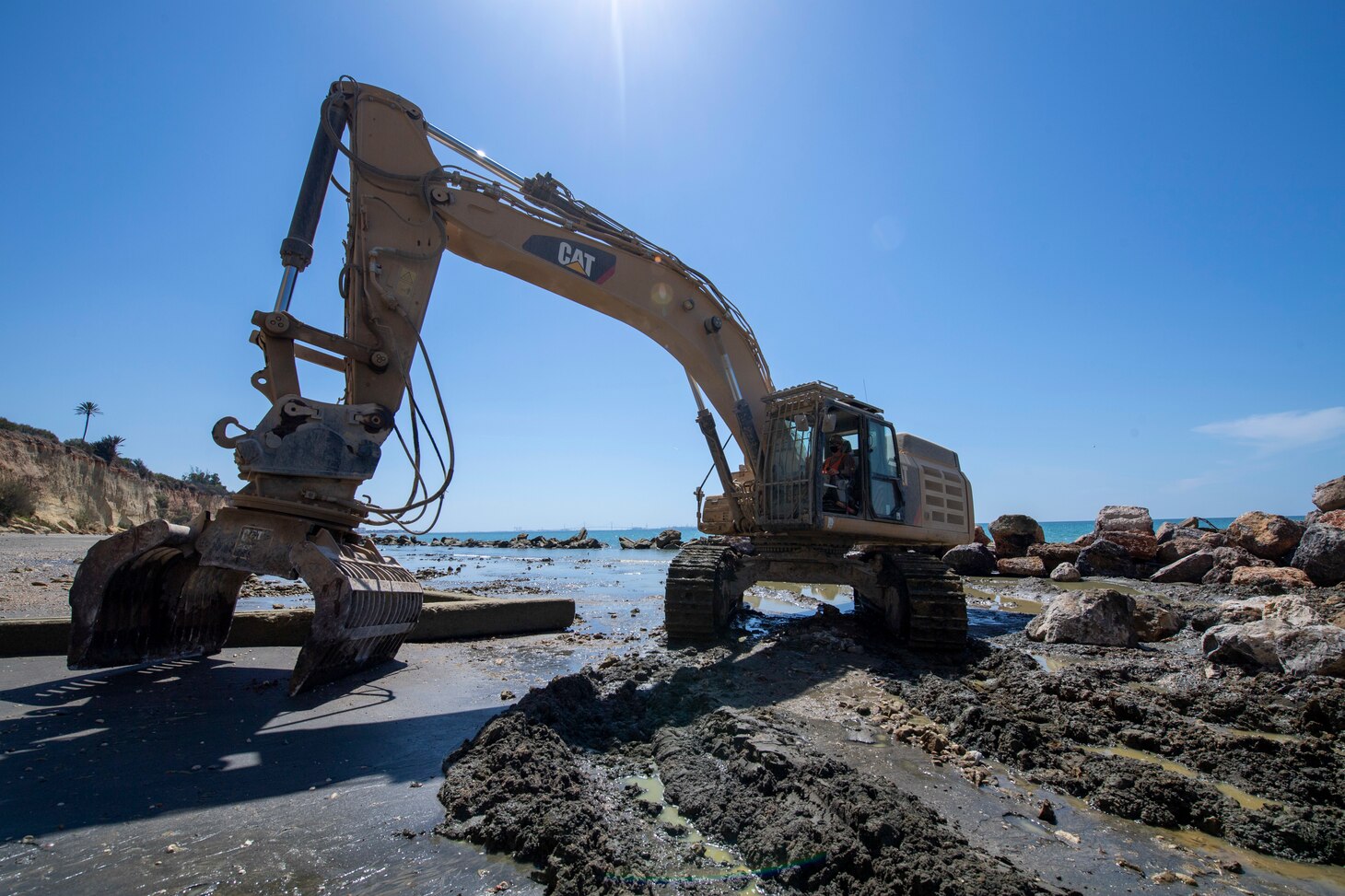 200910-N-RH019-0002 ROTA, Spain, (Sept. 10, 2020) Equipment Operator Constructionman Zachary Owen, from Houston, attached to Naval Mobile Construction Battalion (NMCB) 133 operates an excavator placing an under layer during coastal erosion restoration onboard Naval Air Station Rota, Sept. 10, 2020. CTF 68 provides explosive ordnance disposal operations, naval construction, expeditionary security, and theater security efforts in the 6th Fleet area of responsibility. (U.S. Navy photo by Mass Communication Specialist 2nd Class Sean Rinner/Released)