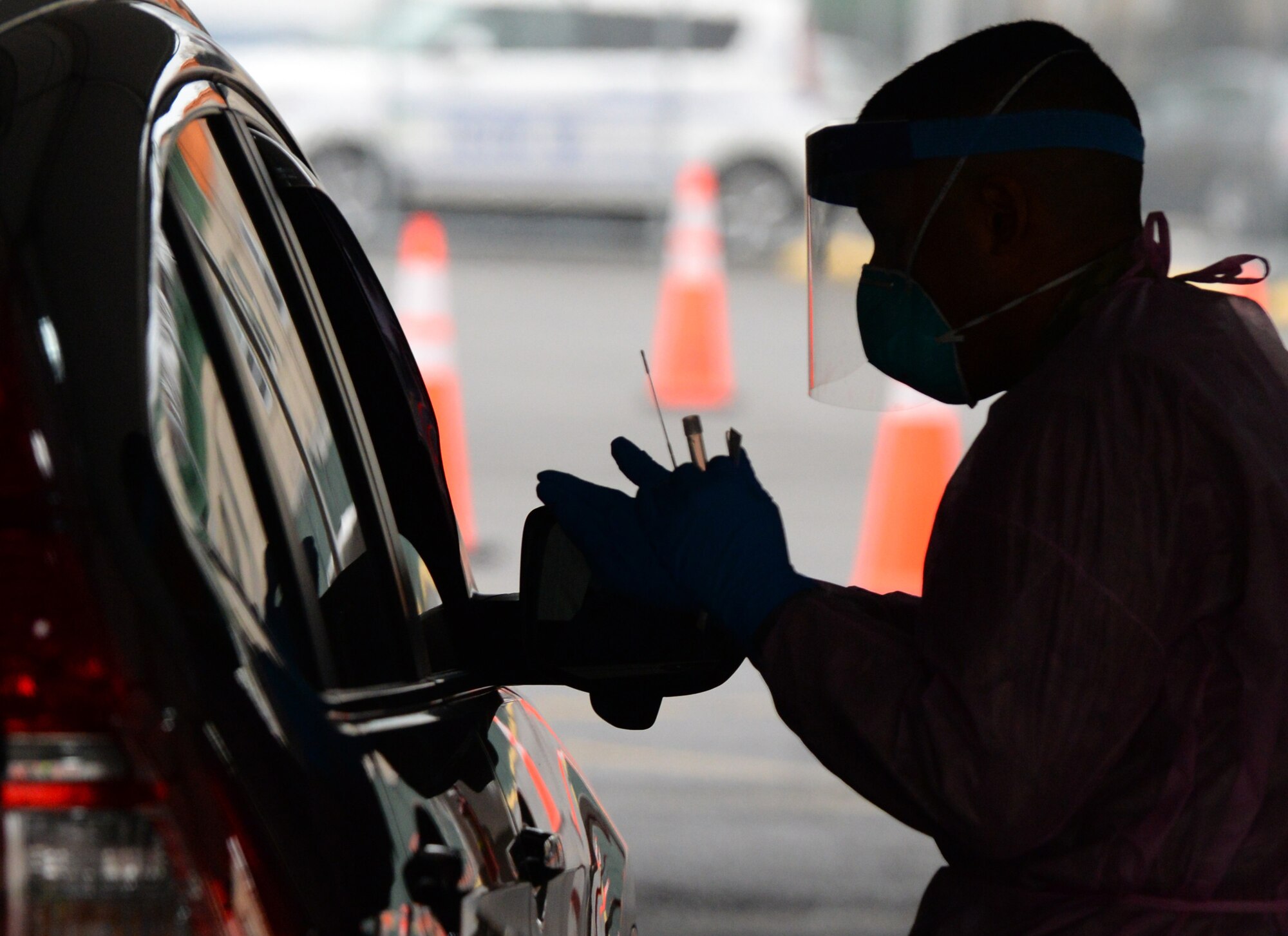 Pfc. Gian Zimnis, a Combat Medic Specialist from Queens, N.Y., assigned to the New York Army National Guard, instructs a motorist before administering a swab, to test for COVID-19 infection in Brooklyn, N.Y., April 20, 2020. Drive-thru sample collection sites have been set up as part of New York’s multi-agency response to COVID-19. (U.S. Air National Guard photo by Senior Airman Sean Madden)