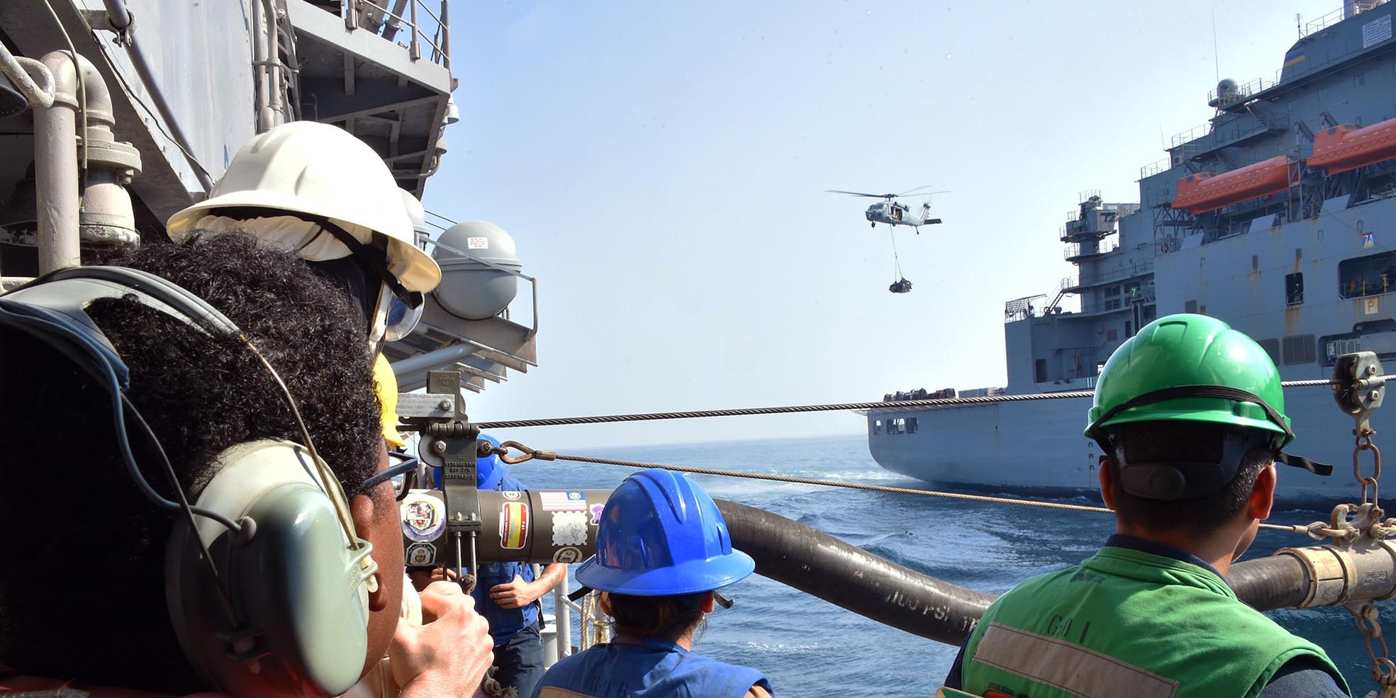 An MH-60S Seahawk helicopter transports cargo from the Military Sealift Command dry cargo and ammunition ship USNS Matthew Perry (T-AKE 9) to the guided-missile cruiser USS Philippine Sea (CG 58) during a vertical replenishment-at-sea in the Arabian Sea, Oct. 7.