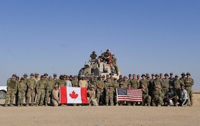 U.S. Army Soldiers, U.S. Air Force Airmen and Canadian Armed Forces members pose for a photo at the Udairi Range Complex, Kuwait, Oct. 12, 2020. The range day event was an opportunity to maintain key working relationships with mission partners in the joint and multi-national Special Operations Command Central network. (U.S. Air Force photo by Senior Airman Monica Roybal)