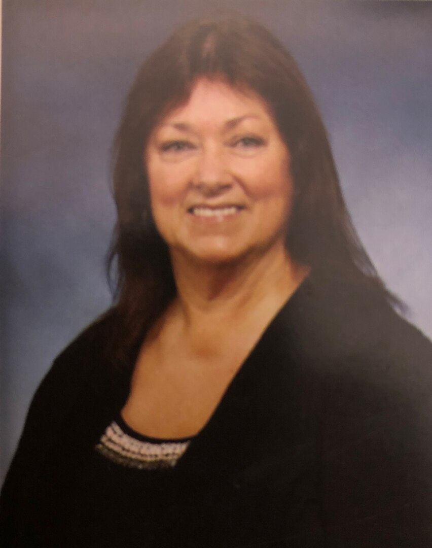 A lady in a black outfit with a blue background