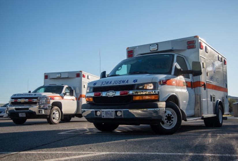 Two ambulances are parked outside.