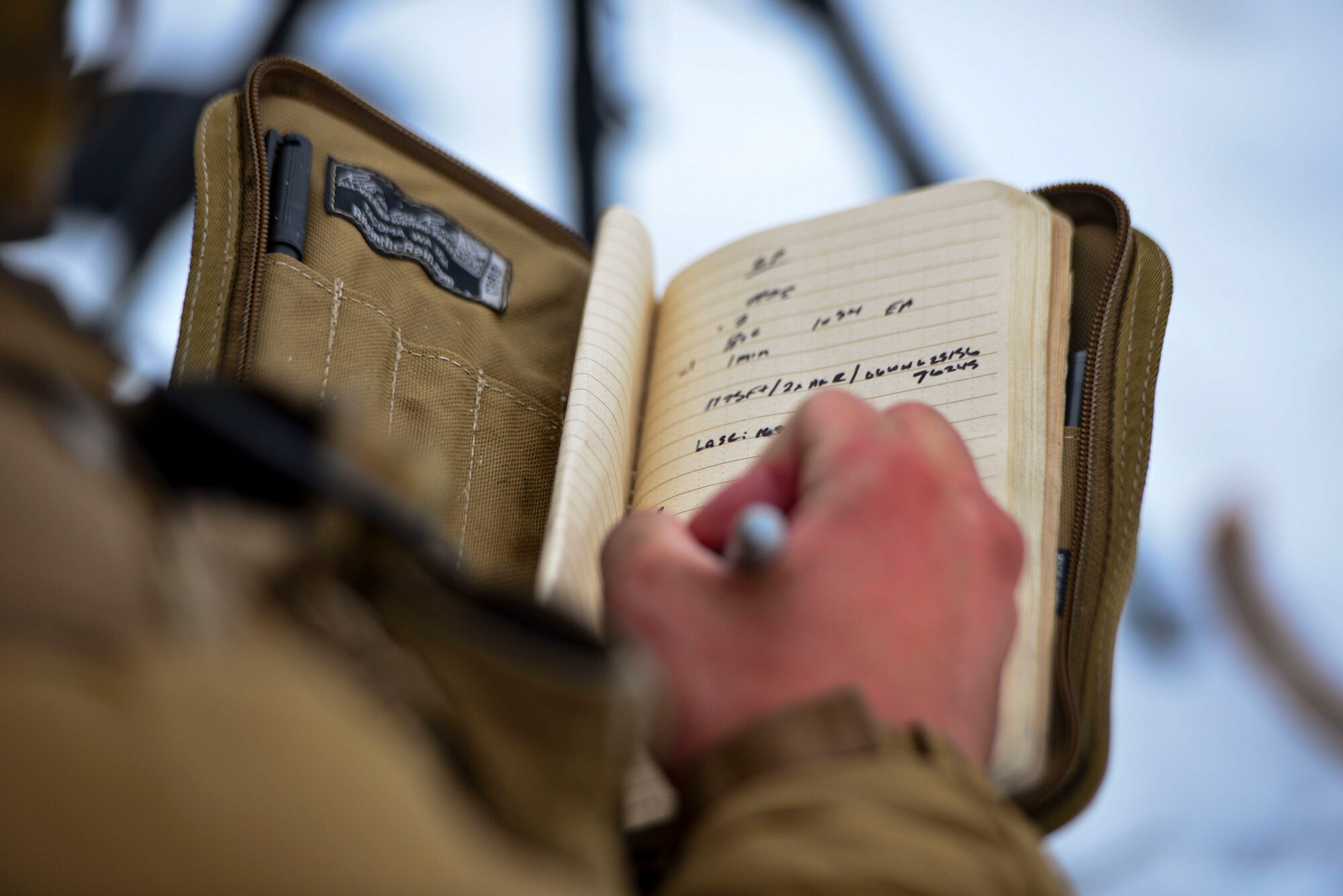 U.S. Marine Corps Lance Cpl. Jarrett Dittenber, a 1st Air Naval Gunfire Liaison Company forward observer, writes down target data during RED FLAG-Alaska 21-1 in the Joint Pacific Alaska Range Complex, Oct. 15, 2020.