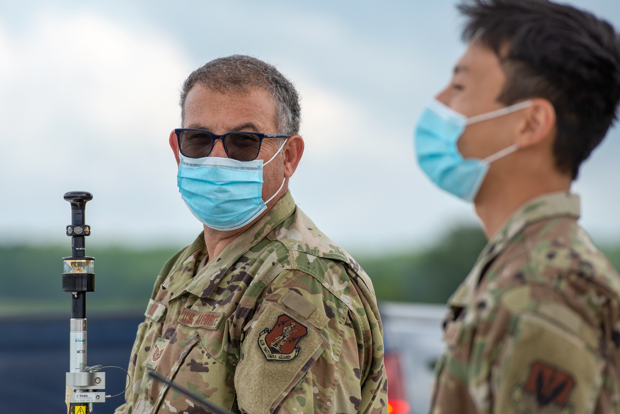 A photo of Tech. Sgt. Peter G. Kurt and Staff Sgt. Kevin H. Tan using a Trimble prism.