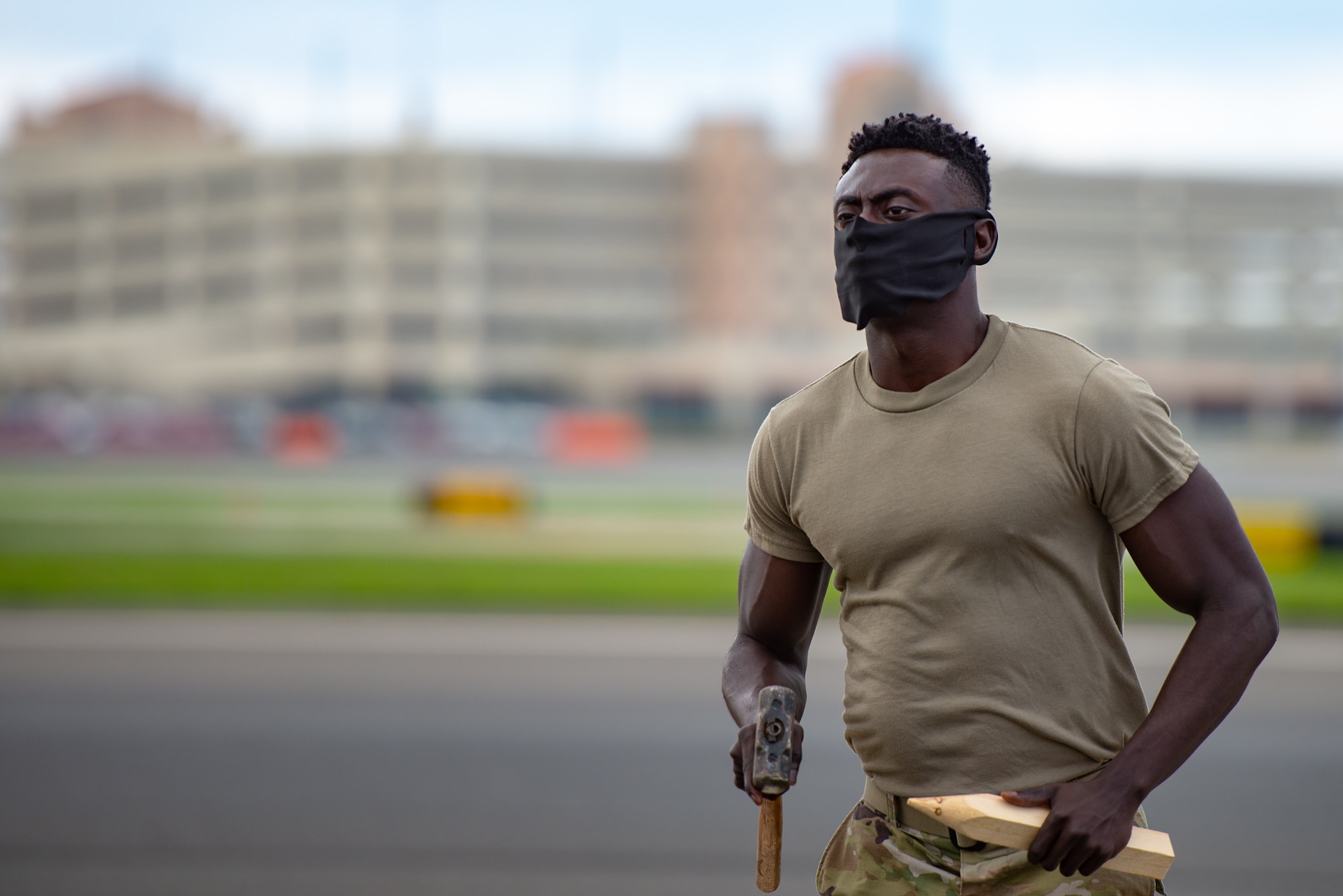 A photo of Staff Sgt. Derick N. Donkor holding a hammer and wooden stake.