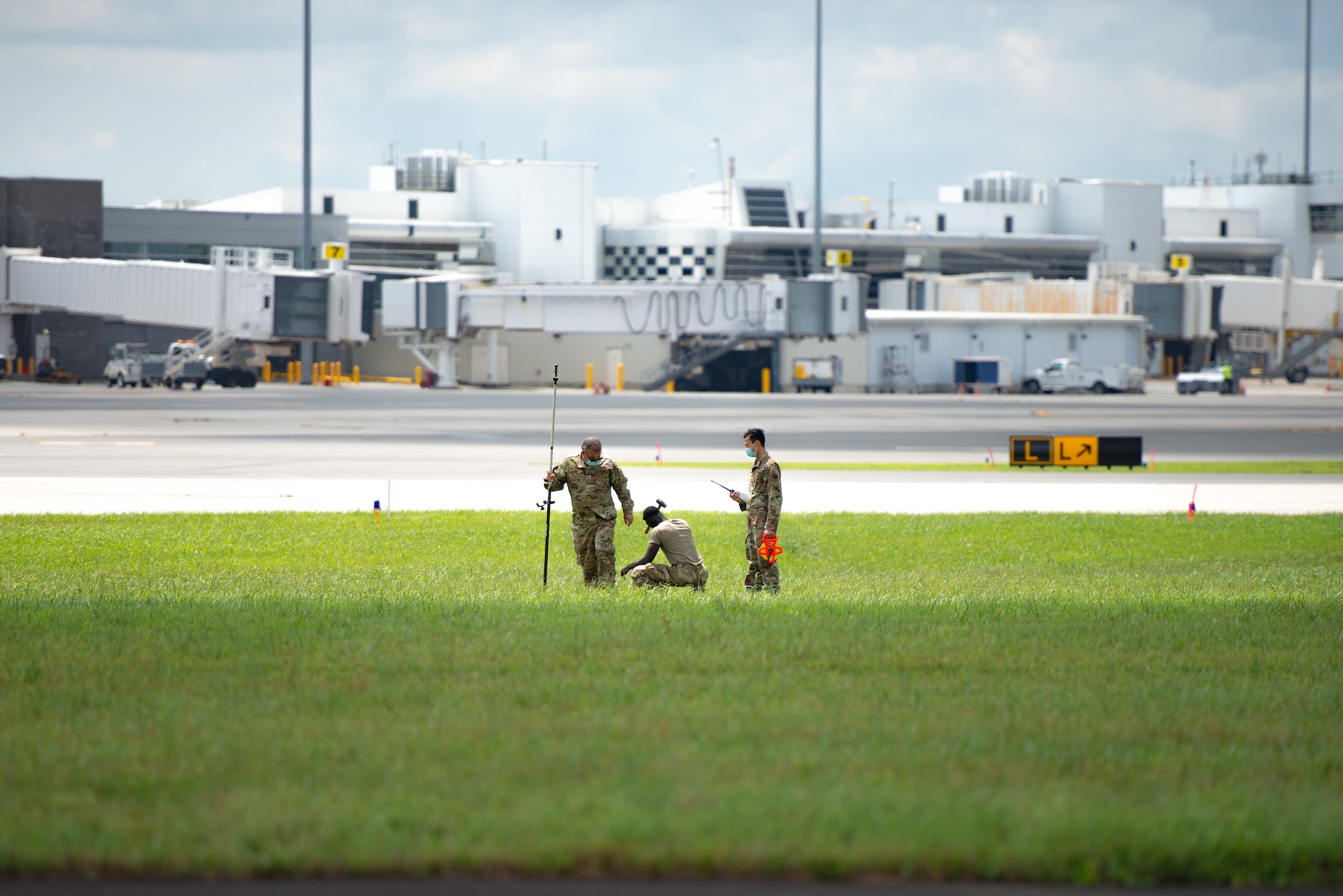 A photo of Staff Sgt. Kevin Tan, Staff. Sgt. Derick N. Donkor and Tech. Sgt. Peter G. Kurt marking specific locations to put stakes in the ground on the 177th Fighter Wing runway.