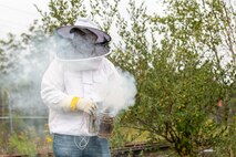 Photo of Environmental Protection Specialist Sean Maynard gets the smoker ready to sedate the honey bees prior to opening the hive.