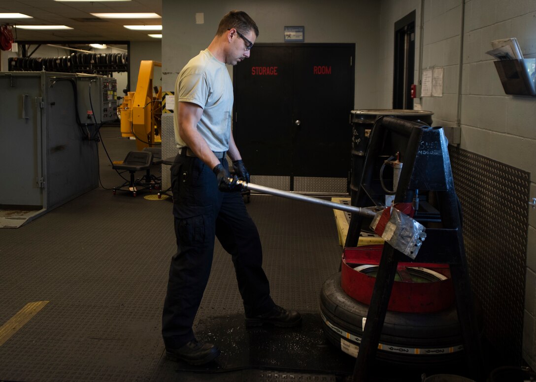 Senior Airman Lyman Patee, 4th Equipment Maintenance Squadron crash recovery wheel and tire craftsman, uses a manual tire bead breaker to mate a tire to a wheel at Seymour Johnson Air Force Base, North Carolina, Oct. 14, 2020.