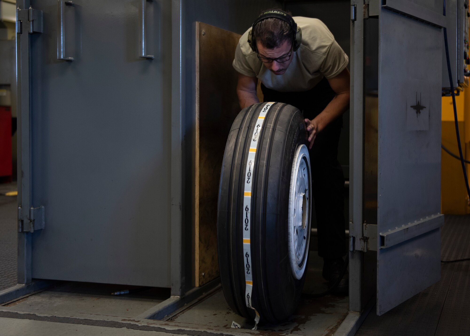 Senior Airman Lyman Patee, 4th Equipment Maintenance Squadron crash recovery wheel and tire craftsman, rolls a wheel out of an air cage after inflating the tire at Seymour Johnson Air Force Base, North Carolina, Oct. 14, 2020.