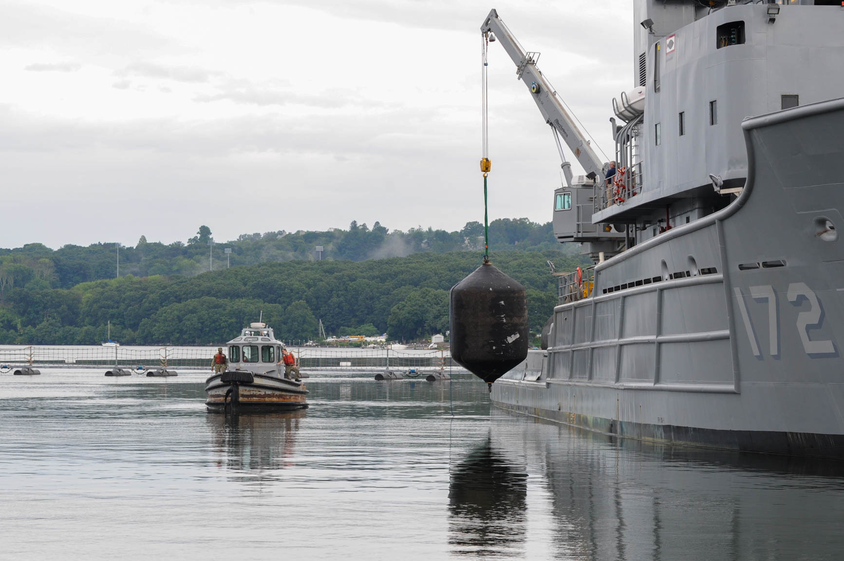 Military Sealift Command's fleet ocean tug USNS Apache (T-ATF 172) lowers a fender down to be retrieved.