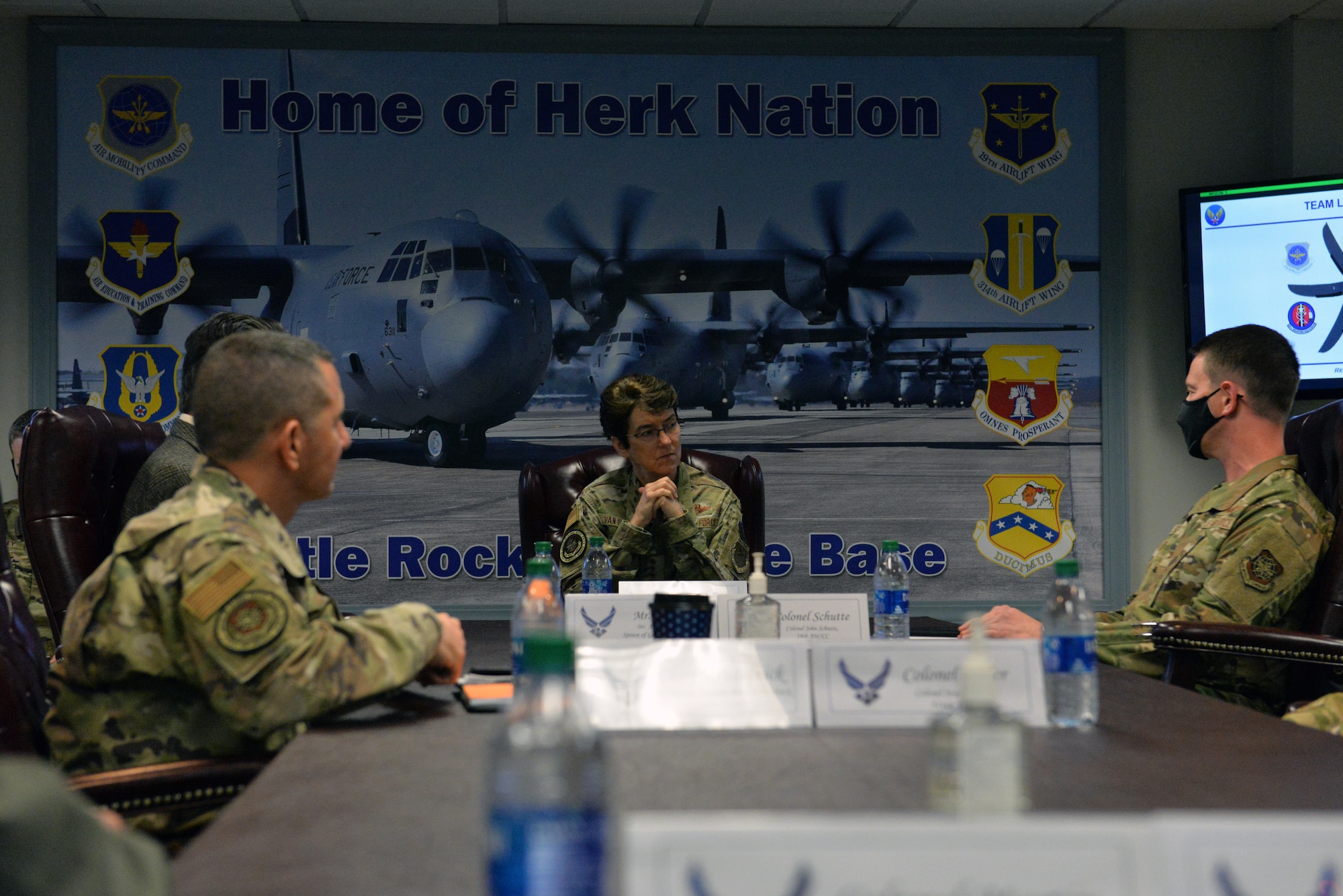 woman being briefed by two men at conference table