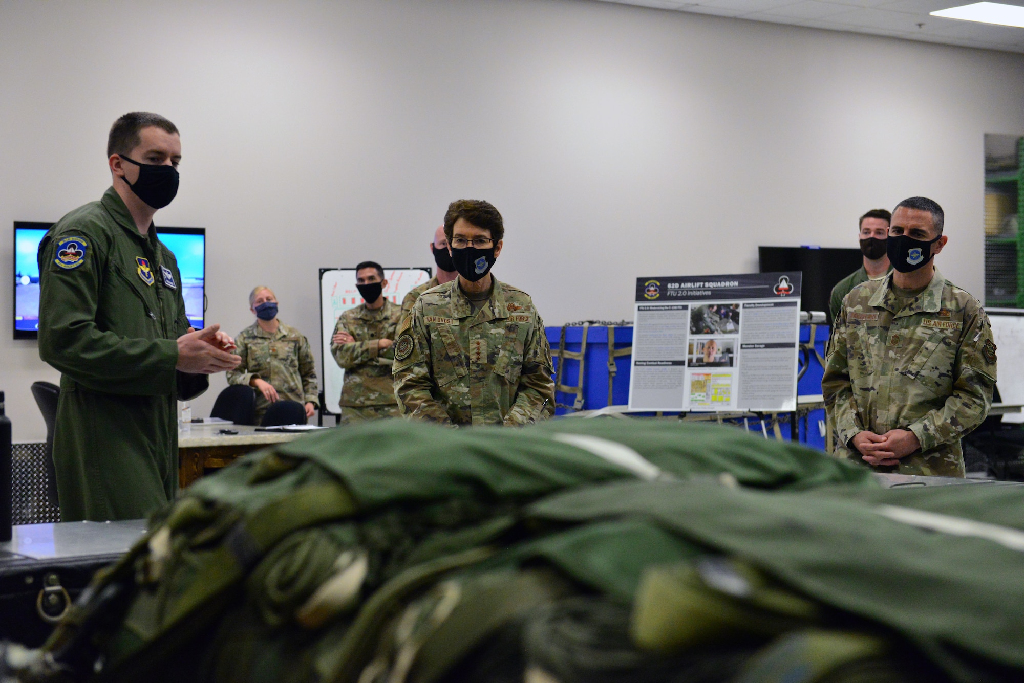 man talking to commander with parachutes in foreground