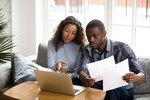 Serious African American couple discussing paper documents