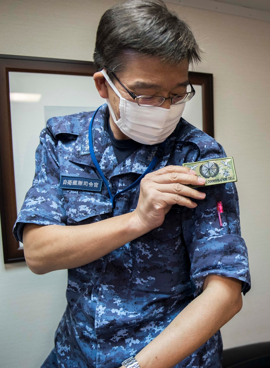 Vice Adm. Hideki Yuasa, commander in chief, Self Defense Fleet, Japan Maritime Self Defense Force, dons an Enforcement Coordination Cell (ECC) patch, presented to him by ECC Director, Capt. James J. Mehail,  during a visit to the 7th Fleet command ship, USS Blue Ridge (LCC 19). As the U.S. Navy’s largest forward-deployed fleet, there are roughly 50-70 ships and submarines, 150 aircraft, and approximately 20,000 Sailors operating in the 7th Fleet area of operations.