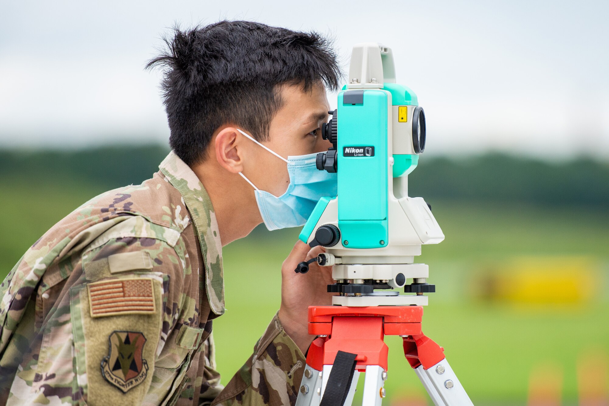A photo of Staff Sgt. Kevin Tan looking through a Nikon NPL-322+ P Series Total Station.
