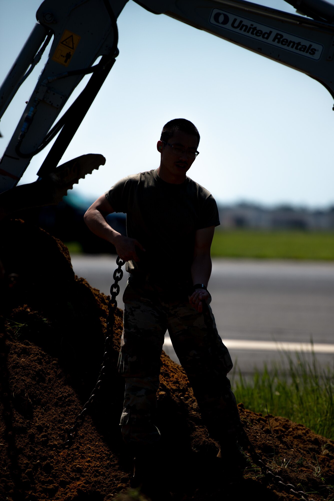 A photo of Airman 1st Class Alejandro Ng Feng fastening a chain.