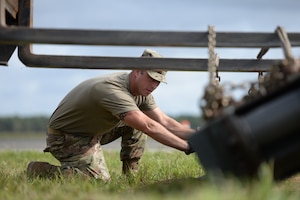 A photo of Tech. Sgt. Anthony J. Foster assisting the installation of a mobile arrestor system.