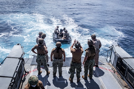 U.S. Marines and Sailors prepare to load a combat rubber raiding craft on a Mk VI patrol boat assigned to Commander, Task Force (CTF) 75, during maritime operations.