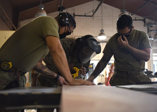 U.S. Air Force Staff Sgt. Jonathan Gonzales, 51st Civil Engineer Squadron structural craftsman (left), Senior Airman Eugene Dairyko, 51st CES structural journeyman (center), and Senior Airman William Gilson, 51st CES structural journeyman (right) cut out stringers to complete stairs for a dollhouse project during Silver Flag expeditionary training at Osan Air Base, Republic of Korea, Sept. 2, 2020. For the first time ever at Osan, Silver Flag’s 554th Rapid Engineer Deployable Heavy Operational Repair Squadron Engineers (REDHORSE) mobile training team challenged Airmen and Sailors across the globe. The participants collectively maximized their ability to set up a bare base, and employ reliable sustained and recovery operations. (U.S. Air Force photo by Senior Airman Denise Jenson)