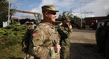 Oregon National Guard 1st Lt. Robert Boyer observes as a team of Italian Army Hazmat soldiers approaches a building storing chemical waste and Kosovo Security Forces CBRNE (Chemical, Biological, Radiological, Nuclear, and Explosives) company suit up in white chemical protective gear Oct. 1, 2020, at one of Kosovo’s largest energy plants in Obilic/Obiliq.