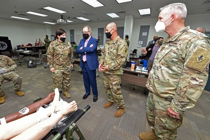 Lt. Col. Kathleen Samsey and Capt. Cesar Veliz provide Thomas McCaffery, Assistant Secretary of Defense for Health Affairs, and Maj. Gen. Dennis LeMaster, commanding general, U.S. Army Medical Center of Excellence, a briefing on the patient simulators used to teach students during the Combat Paramedic course at Joint Base San Antonio-Fort Sam Houston Oct. 19.