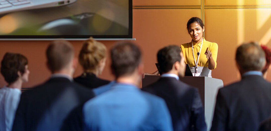 Women at a podium talking to a crowd