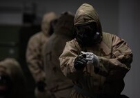 Airman adjusts his MOPP gear.