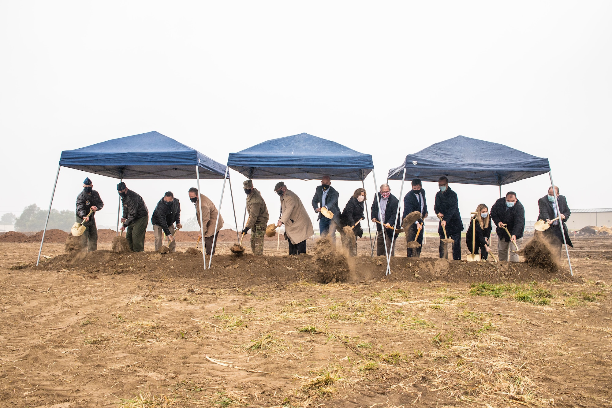 Distinguished visitors shoveling dirt