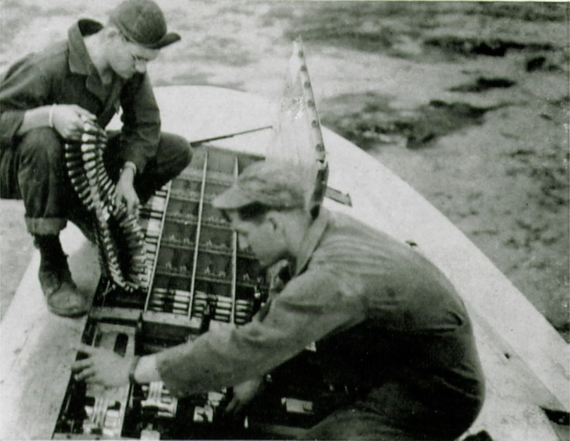 Armorers Sgt. Douglas J. Wood and Sgt. Robert C. Dyson of the 406th Fighter Squadron “loading them hot.” (The Story of the 371st Fighter Group in the E.T.O.)
