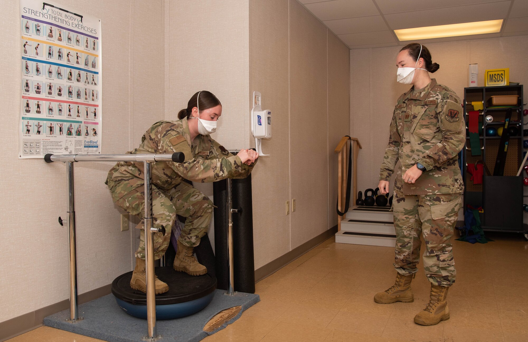 U.S. Air Force Capt. Jenna Boyd monitors an Airman performing Bionic Oscillatory Stabilization Unit Ball squats.