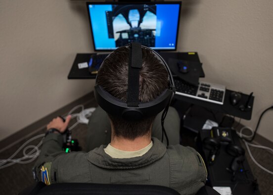A photo of a pilot training on a VR simulator