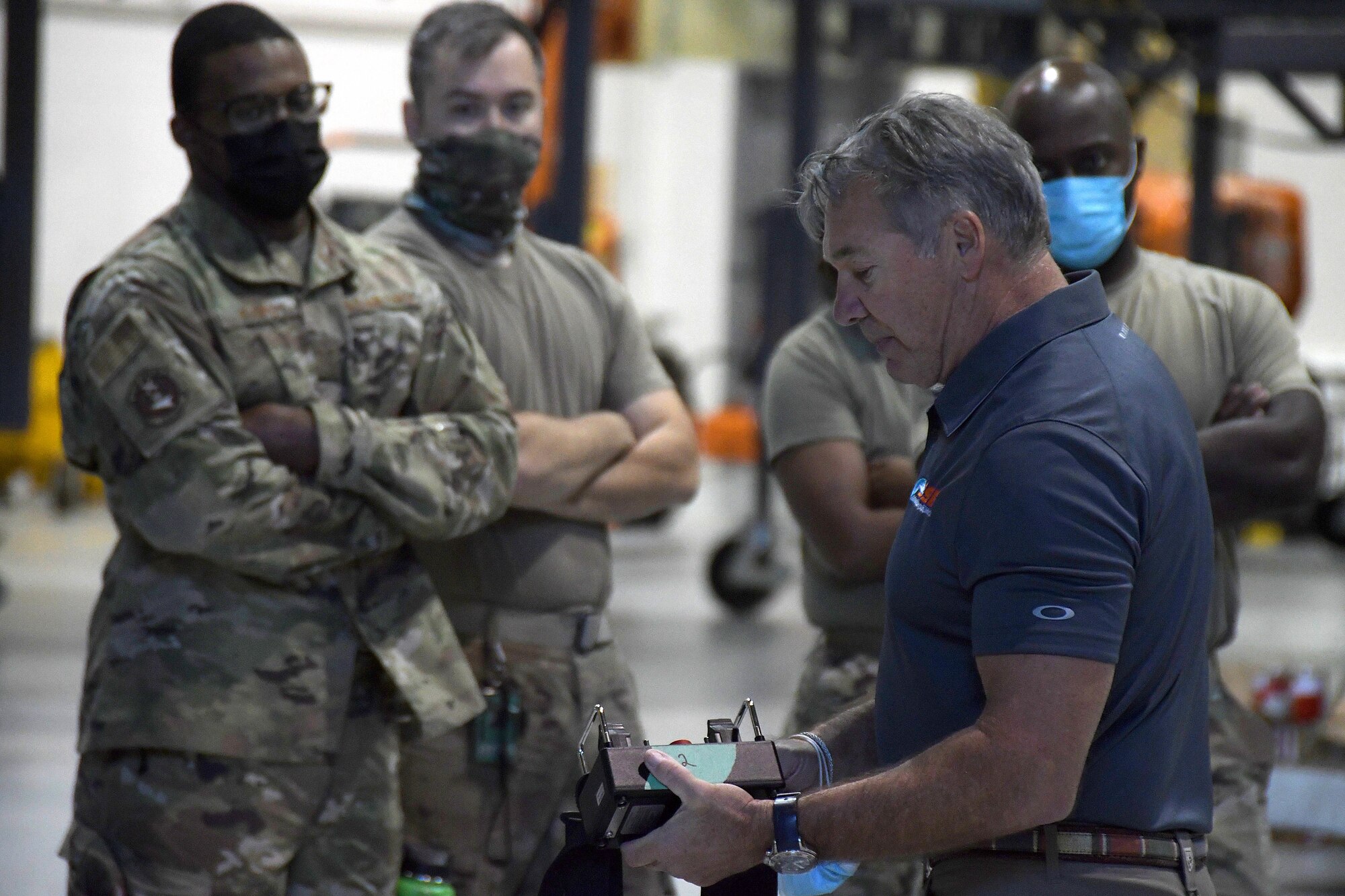 A contractor highlights the features of a remote control to a group of maintainers during a training session at Dobbins Air Reserve Base, Georgia, Oct. 16, 2020. The 94th Aircraft Maintenance Squadron recently acquired several mobile fall protection systems to improve the safety of maintainers and operators as they perform their duties on the aircraft. (U.S. Air Force photo/Andrew Park)
