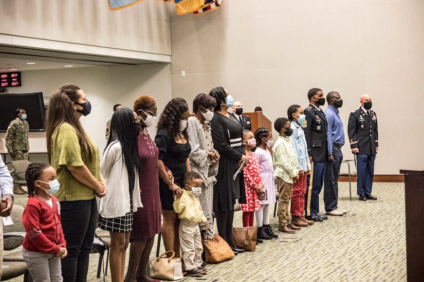 The Rouse family stand to the playing of the retirement medley at U.S. Army Central headquarters on Shaw Air Force Base, S.C., Oct. 7, 2020. The Rouse family were together to attend Tyris' retirement ceremony which turned out to be a surprise reunion for Eldridge and the family. (U.S. Army photo by Pfc. Keon Horton)